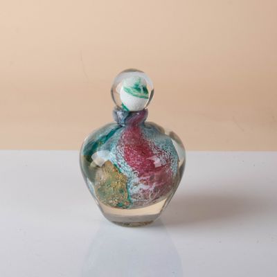 a small glass bottle with a small figurine inside of it