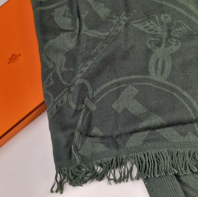 une boîte orange sur laquelle est posé un foulard vert, à côté d'un foulard vert