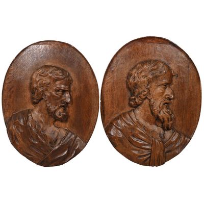 une paire de portraits en bois sculpté représentant un homme et une femme