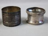 three silver napkin rings sitting on top of a white table