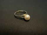 a close up of a ring with a pearl on it