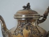 a silver tea pot with a lid on a table