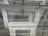 a stack of windows sitting on a pallet in a warehouse