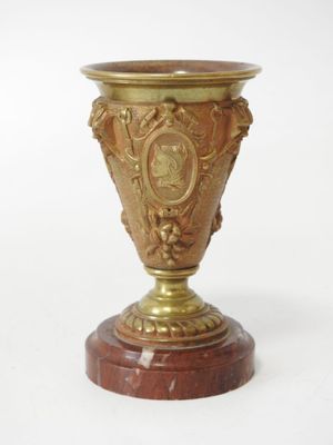 a gold vase sitting on top of a marble base