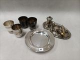 des assiettes, tasses et soucoupes en argent plaqué sur un fond blanc