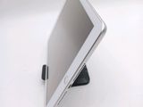 a tablet computer sitting on a stand on a white surface