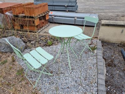 une table et deux chaises dans un espace recouvert de gravier