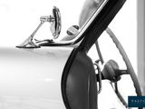 black and white photograph of a classic car with the door open