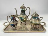 a silver tray with a silver tea set on it