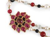 necklace with red, white, and black beads and a flower pendant