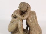 statue of a man and a woman sitting on a white surface