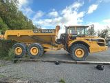 a large yellow dump truck parked on top of a parking lot