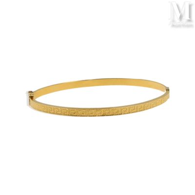 un bracelet rigide en or au motif texturé