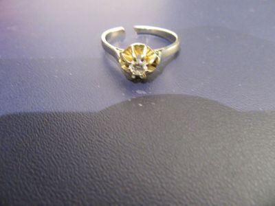 une bague en or ornée d'une fleur, posée sur une table