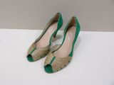 a close up of a pair of green shoes on a white surface