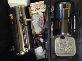une personne debout à côté d'une valise remplie de café et d'autres objets
