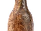 un vase brun posé sur une surface blanche