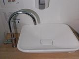 a white sink sitting on top of a wooden counter