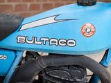 a close up of a blue motorcycle parked in front of a brick wall