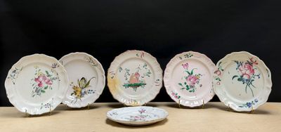 quatre assiettes ornées de fleurs et d'oiseaux sont posées sur une table