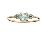 un gros plan d'une bague en or sertie d'une pierre verte et blanche