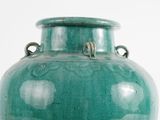 a large green vase sitting on a white surface