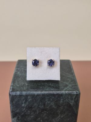 a pair of blue sapphire earrings sitting on top of a marble block