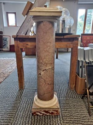 a marble column on the floor in a room