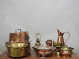 une table en bois sur laquelle sont posés des casseroles et des poêles en cuivre