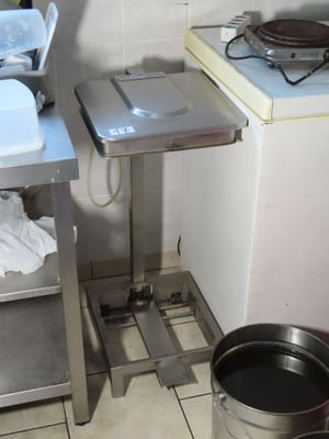une petite cuisine équipée d'un évier, d'une cuisinière et d'une poubelle