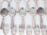 a lot of spoons and forks that are on the table