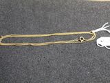 a close up of a gold chain with a tag on it