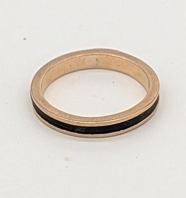 une bague en or avec une bande noire sur un fond blanc