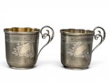 une paire de tasses en métal argenté avec des anses et des poignées