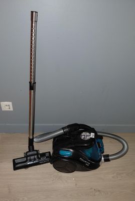 un aspirateur posé par terre à côté d'un sac
