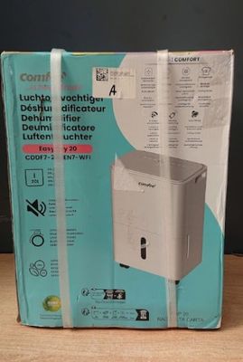 emballage d'une boîte destinée à un humidificateur posé sur une table en bois