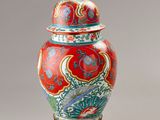 an image of a red and blue vase with a lid on a stand