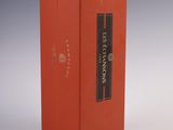 a red box with a black label on it sitting on a white surface