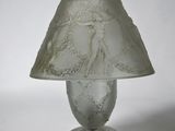 a glass lamp that has a white shade on it
