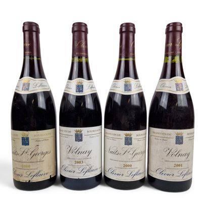 quatre bouteilles de vin sont alignées sur une surface blanche