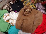 une valise remplie de vêtements et un ours en peluche