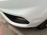 a close up of a white car parked in a parking lot
