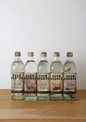 Quatre bouteilles de gin sont alignées sur une table en bois