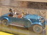 a blue toy car with two dogs in it in a clear box