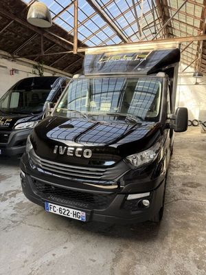 Une camionnette noire est garée dans un garage avec d'autres camionnettes.