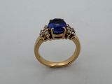 Gros plan sur une bague en or ornée d'un saphir bleu et de diamants