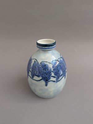 un vase bleu et blanc posé sur une surface grise