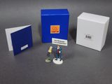 two figurines of a man and a woman standing in front of a blue box