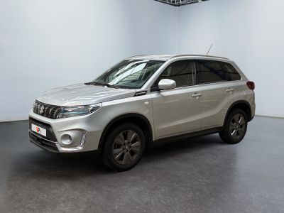 Le SUV argenté est garé dans une pièce blanche au sol noir.