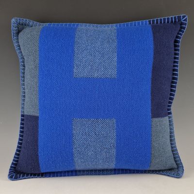un coussin bleu et gris orné d'une croix